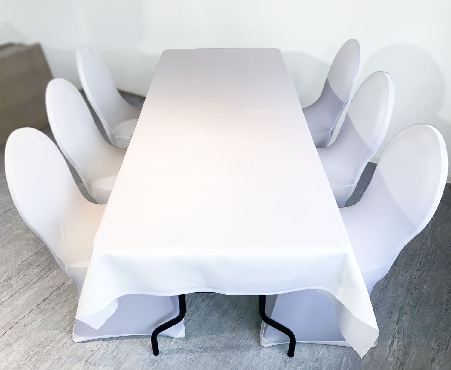 Ansicht von einem gemieteten Banketttisch mit Tischdecken und Bankettstühlen mit Husse
