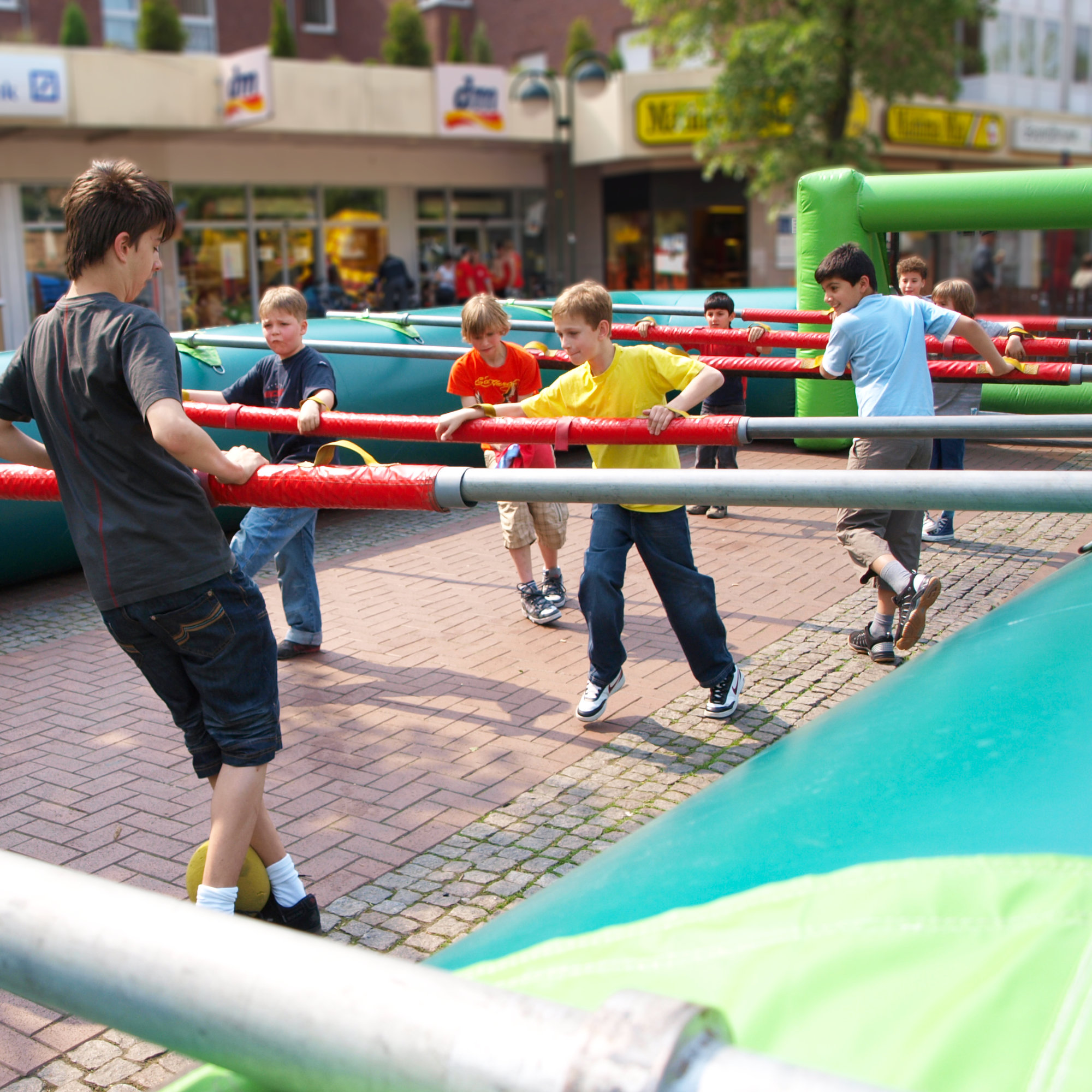 Jugendliche und Kinder haben Spaß beim Fußballspielen im Menschenkicker